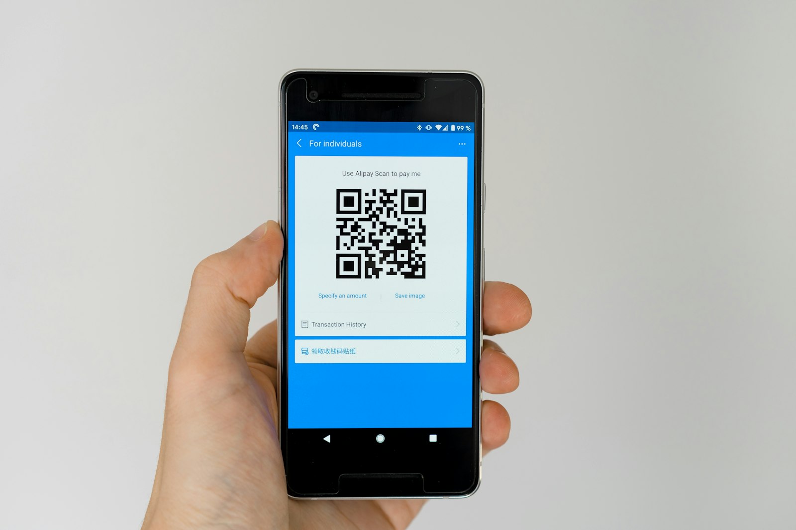 Hand holding a phone displaying a scanned QR code